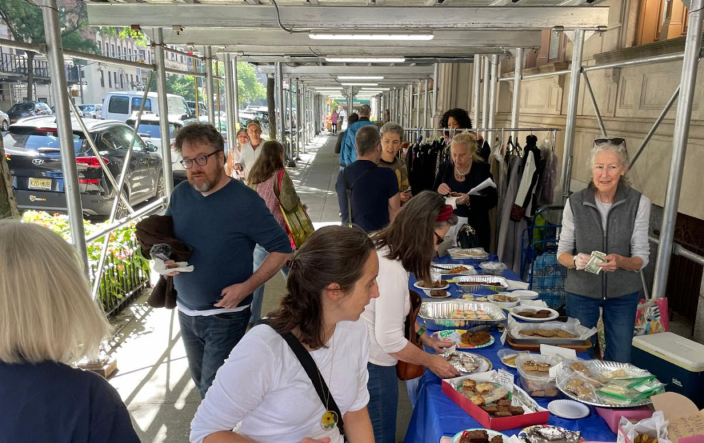 Yard Sale visitors gather beneath scaffolding at 895 West End Avenue, looking at tasty Bake Sale goodies at the Yard Sale.