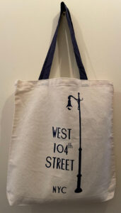 Medium, natural cotton canvas tote with blue cotton handles and blue West 104th Street lamp post logo.