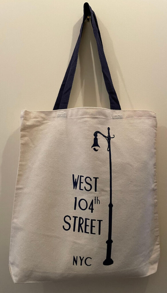 Medium, natural cotton canvas tote with blue cotton handles and blue West 104th Street lamp post logo.