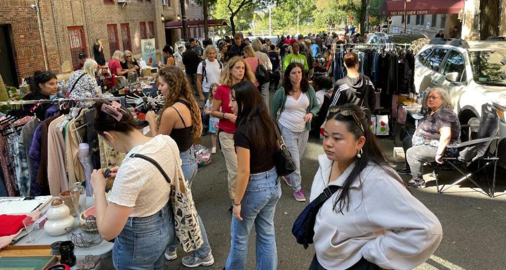 Street scene of yard sale shoppers on a late summer day on West 104th Street between West End Avenue and Manhattan