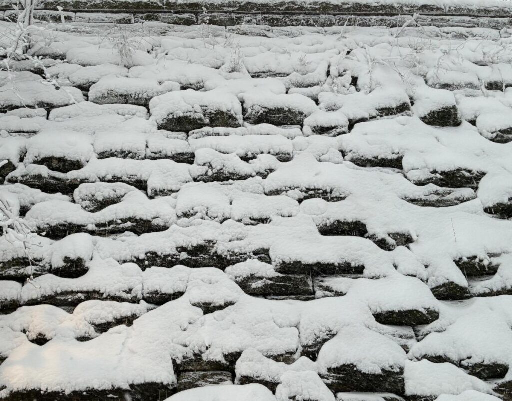 Snow covering a stone wall