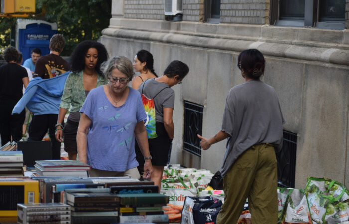 Woman in a lavender shirt browsing at a book table