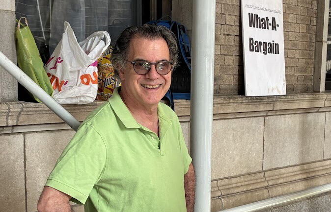 A smiling man with sunglasses and a chartreusse polo shirt