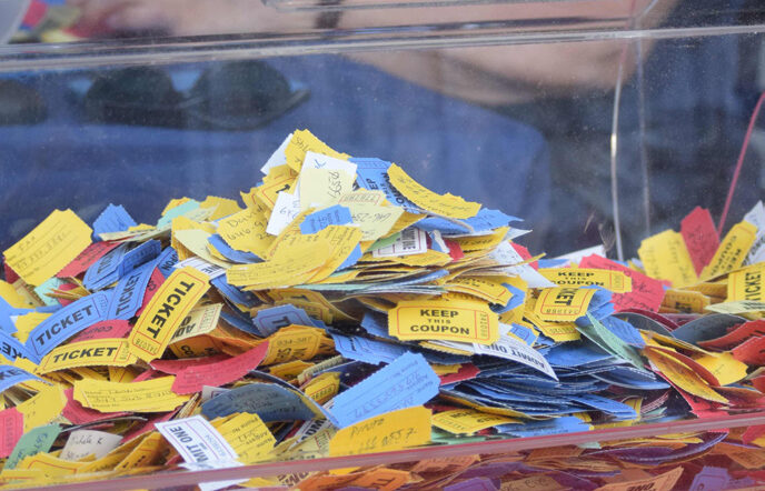 Red, Yellow and Blue raffle tickets, seen through the clear plastic bin