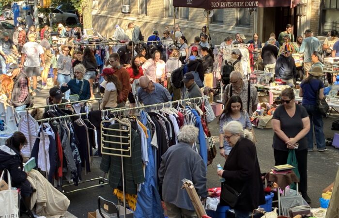 Street scene of shadows strolling the stalls of the 2026 yard sale